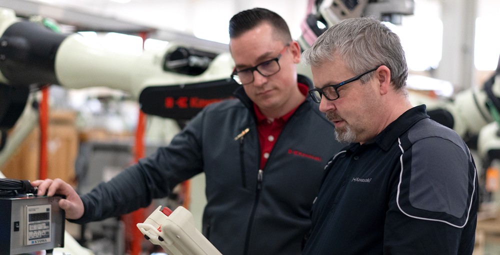 Two men operating the robot